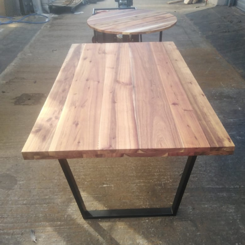 Solid hardwood rectangular table top mounted on a black steel frame base